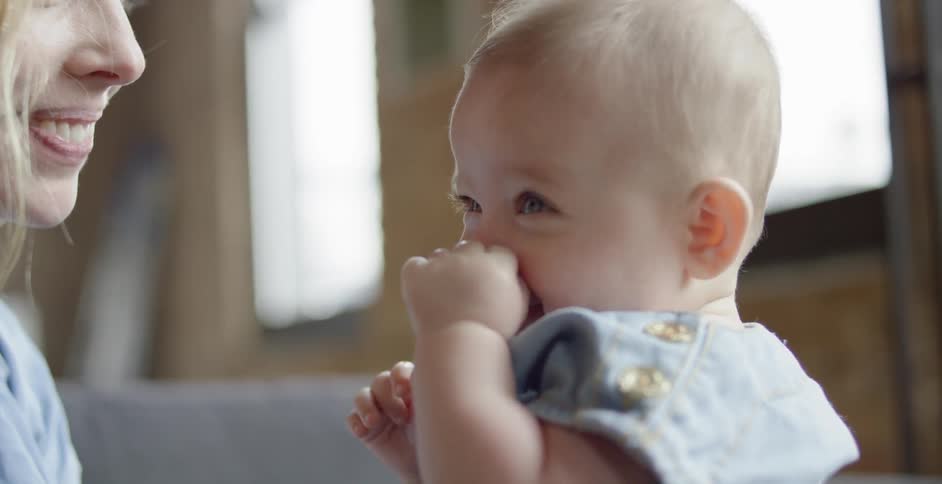 A woman taps a baby's nose
