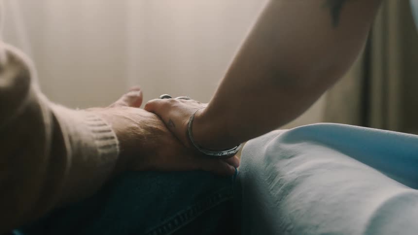 A woman holds a nervous mans hand