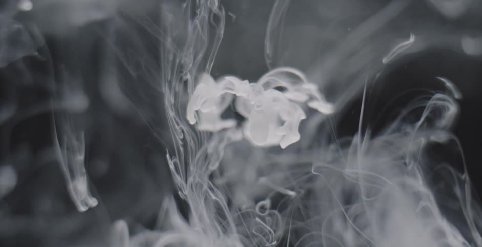 White substance falls and flows into clear liquid