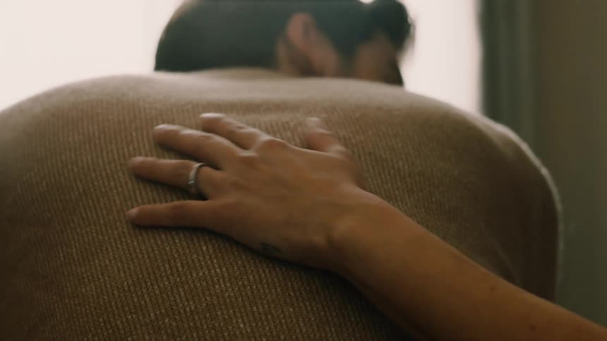 Close up of woman rubbing her male partners back and embracing him shortly after