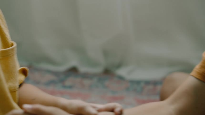 Kids play thumb war while sitting on the floor near the window