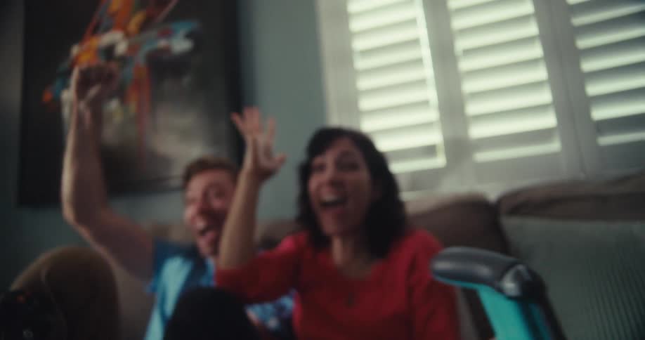 A man and woman celebrate while playing a video game