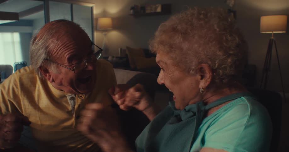 An elderly couple suddenly becomes excited and looks very happy