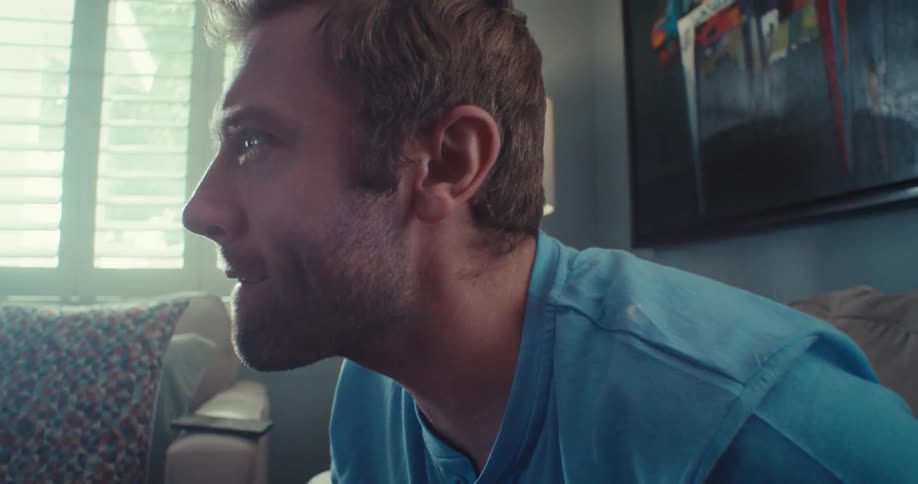 Young couple sitting on a couch focused on playing video games together at home