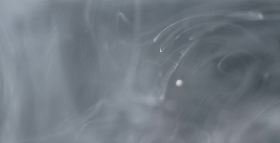 White substance streams and floats in clear liquid