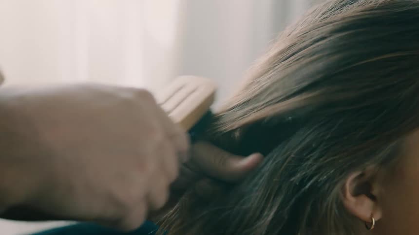 A father brushes his daughters hair