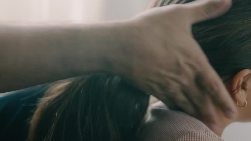 Close up of a male adult arranging and packing a young girls hair into a ponytail