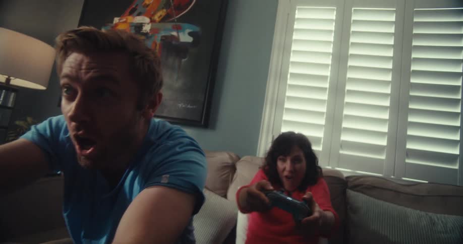 Man and woman compete while playing video games with controllers in a living room