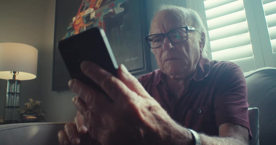 A man is looking at his cell phone at home