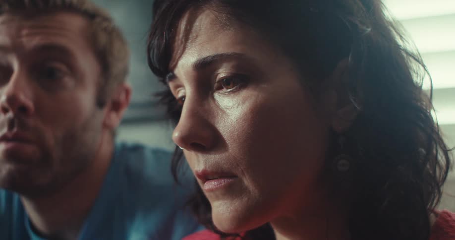 A man and woman look upset as they sit in a living room