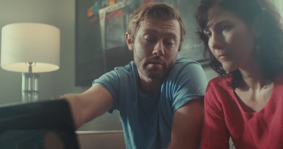 Man and woman sitting interacting with a laptop