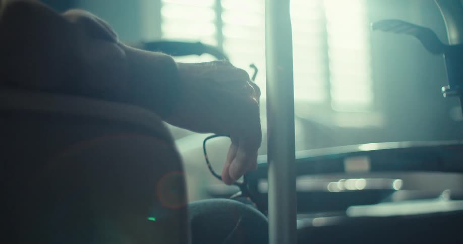 A man is holding his glasses on the couch