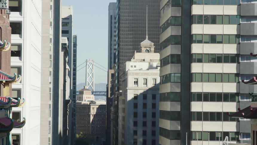 A city skyline featuring a series of highrise buildings under the bright midday sun