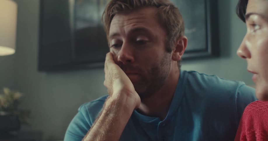 Man looks tired and upset during a discussion with a woman