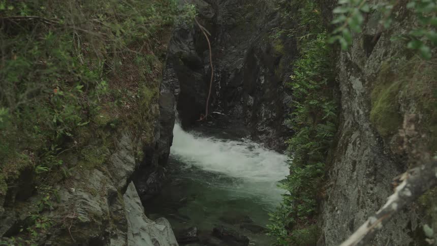 Small waterfall flowing into a pool inside a hidden cave in the canyon