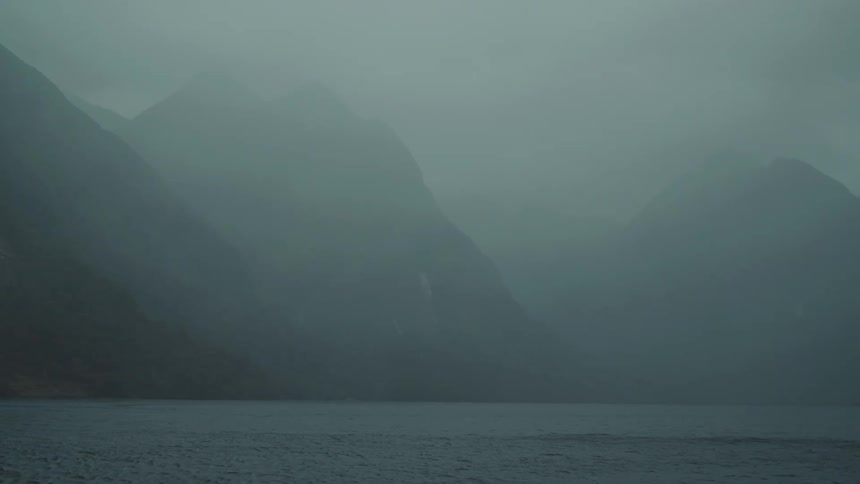 Heavy fog covers the mountains and lake