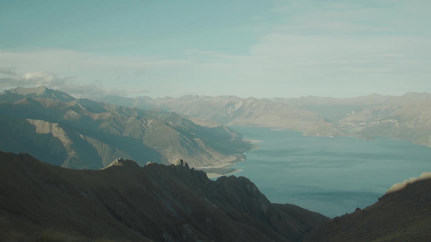 A lake nestled among mountains and valleys creating a serene and picturesque landscape