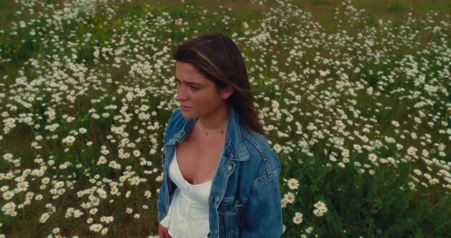 A woman stands in a field of flowers