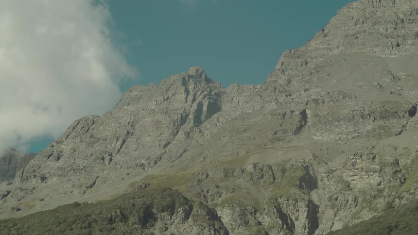 A mountain fills the partially clear sky