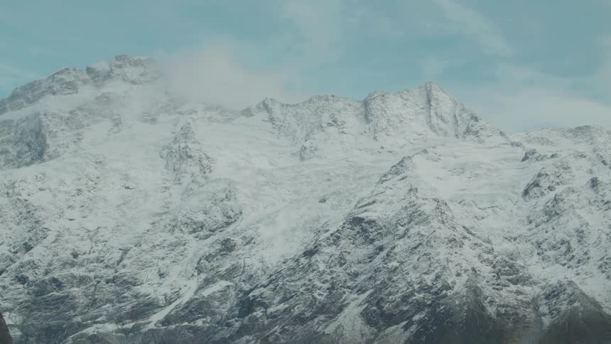 Snowcovered mountains stretch across a vast open landscape