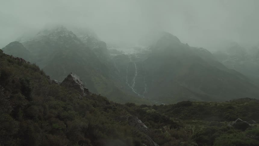 Dense fog obscures the taller mountains in a mountain range