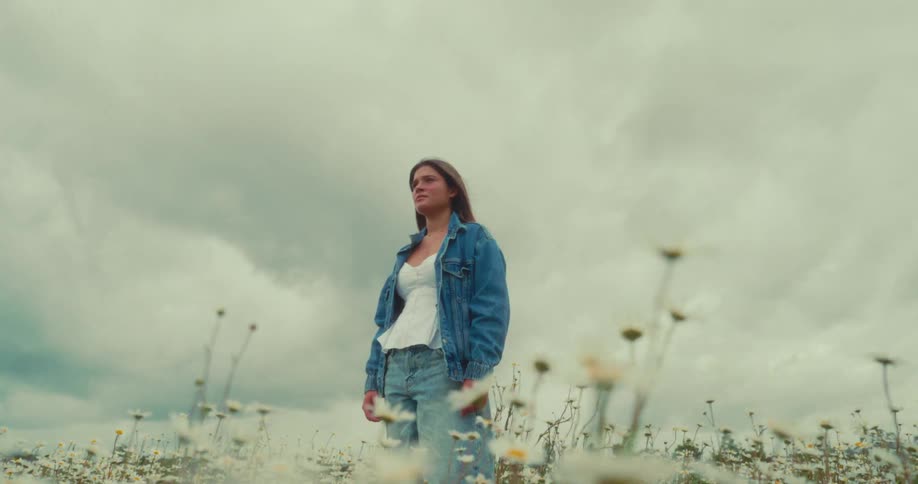 A woman stands in a field of flowers