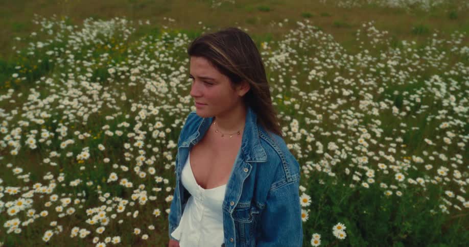 A woman stands in a field of flowers