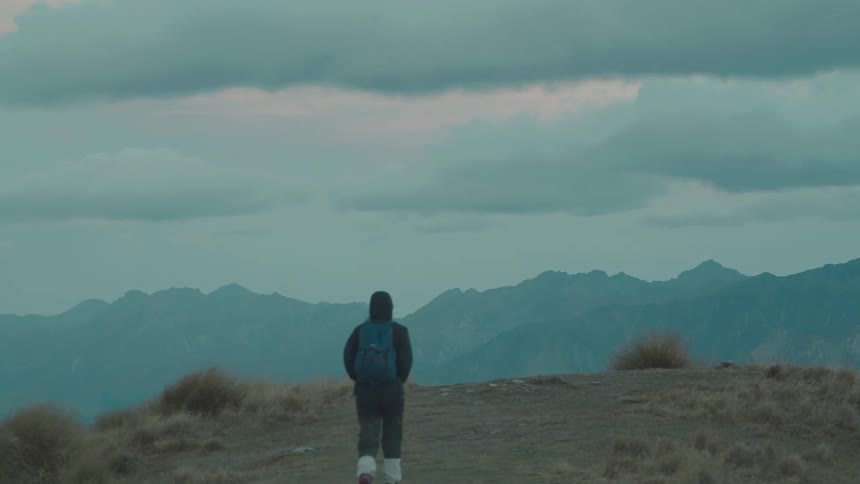 A woman is hiking on a path in the mountains