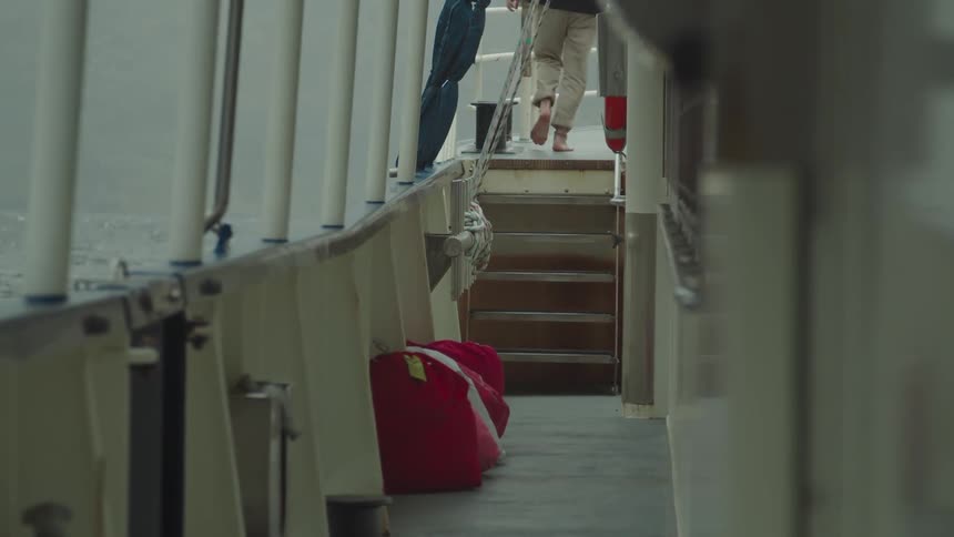Man walks away and climbs a set of stairs in a building by the sea during the day