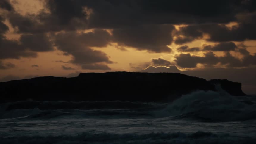 A large wave rolls into the shore and breaks up as it crashes