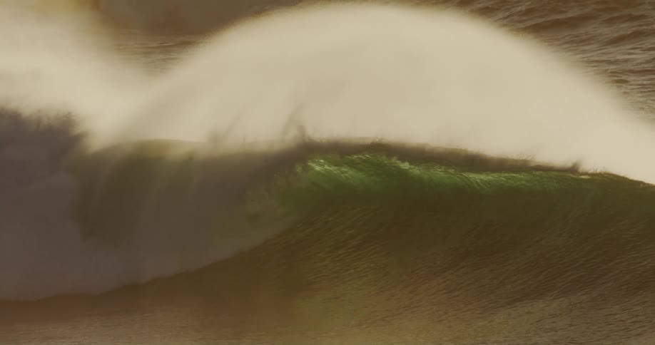An ocean with strong crashing waves under the bright midday sun