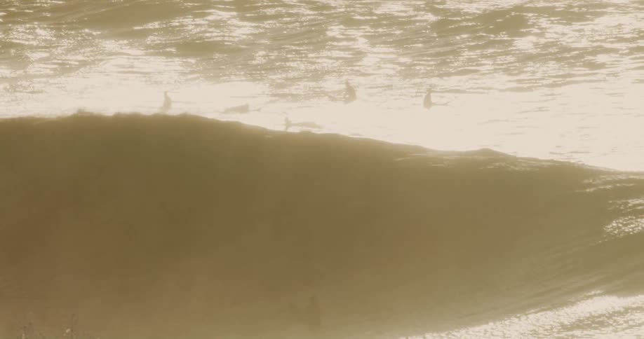 Surfers are resting on their surfboards as they wait for a wave they want to catch