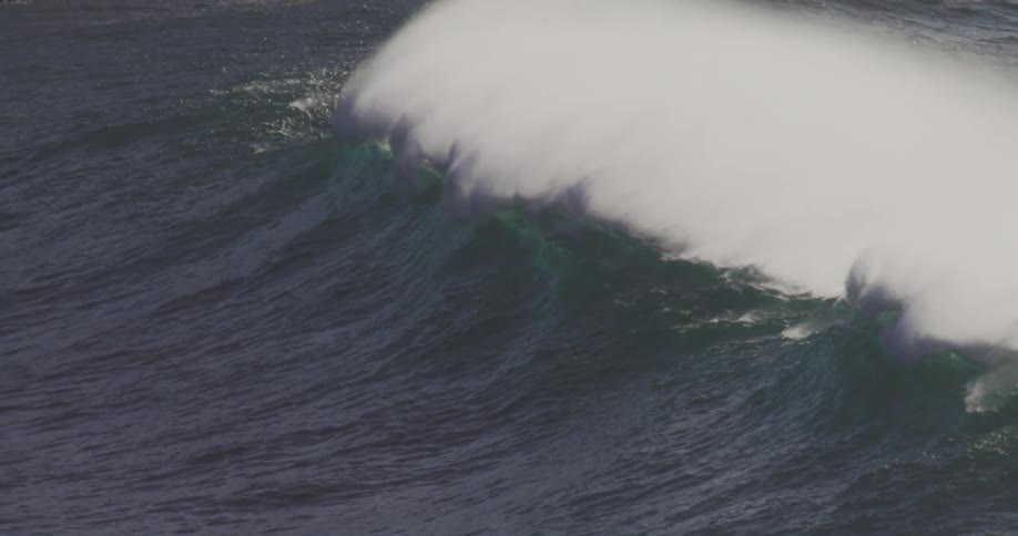 An ocean with strong crashing waves under the bright midday sun