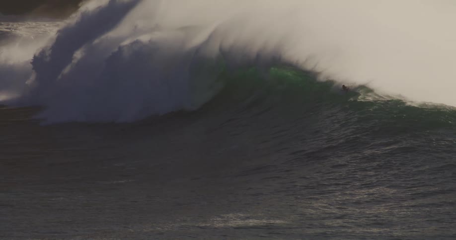 The surfers are riding a large wave that is crashing