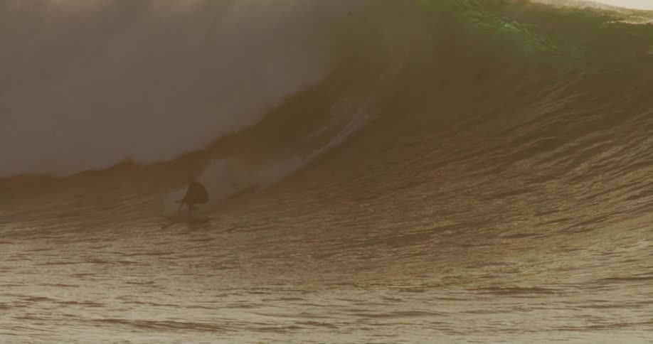 The surfer rides the long wave in the ocean
