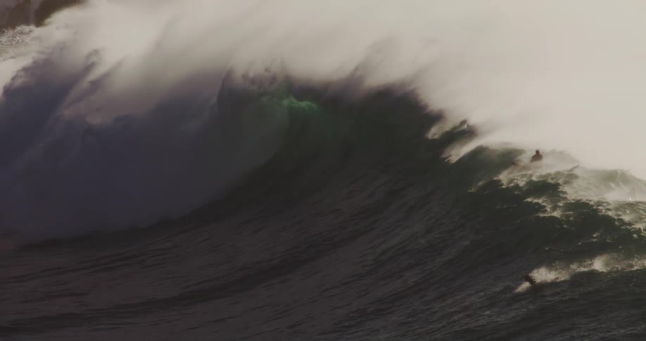 Surfers ride the wave to the shore