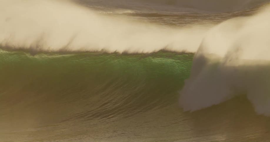Large waves crashed into the ocean creating a foamy substance in the middle of the day