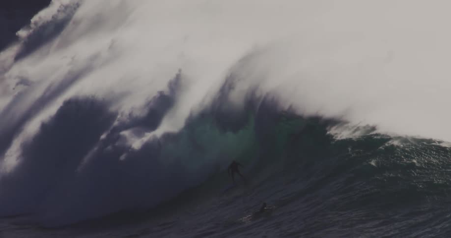 Several surfers ride a huge wave