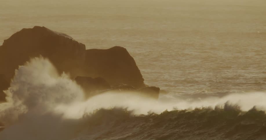 A wave crashes against the rocks