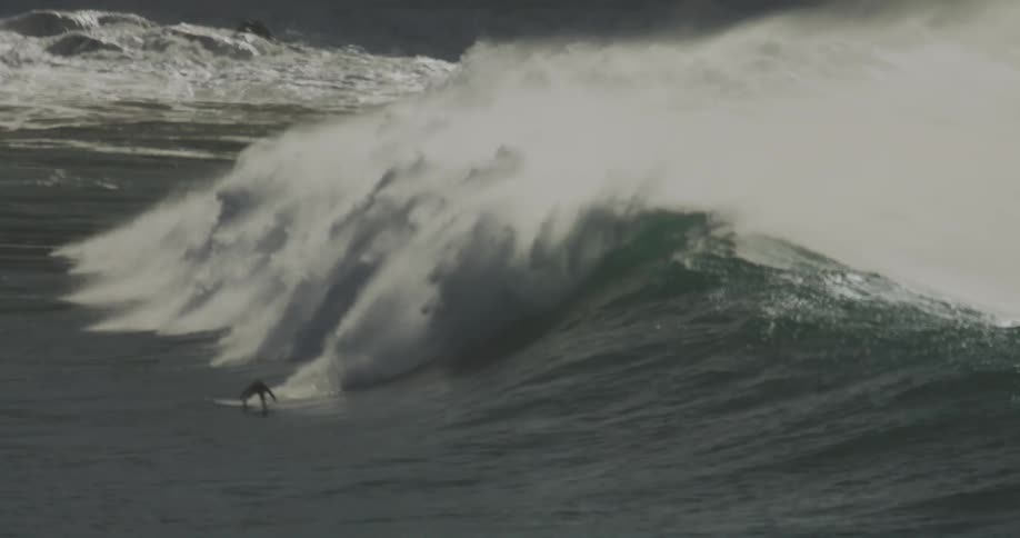 Person surfing a wave and other surfers in the ocean