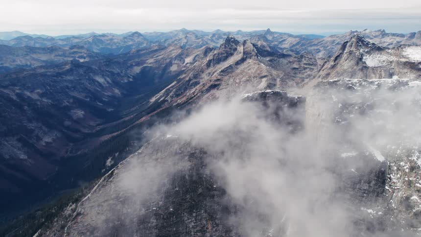 The cloud sits on the very peak of the mountain