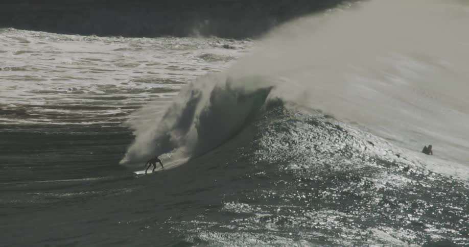 A group of surfers rode ocean waves at midday