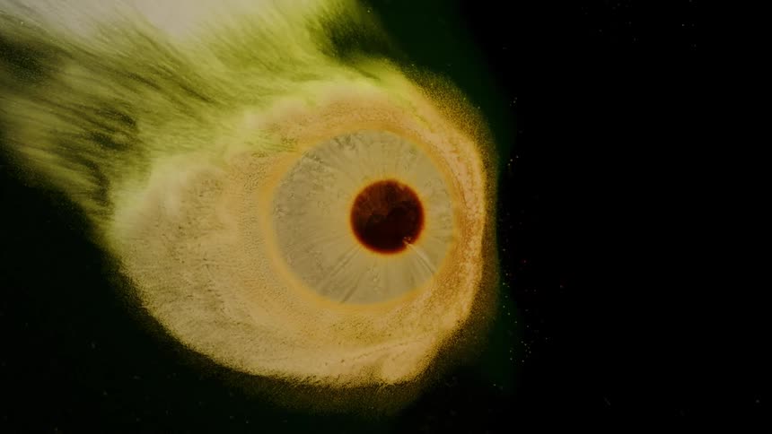 Brown core with yellow organic matter around it against a dark background