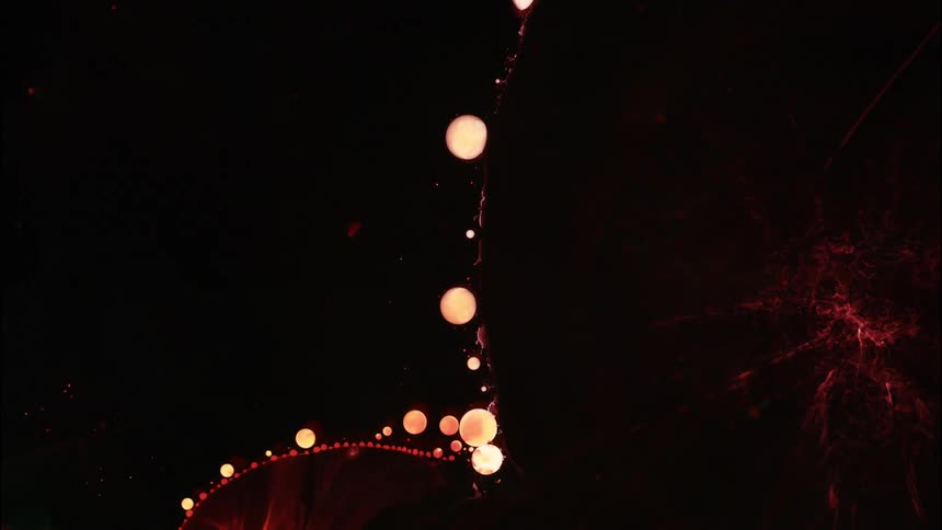 Round liquidlike cells flowing and clustering around a larger circular form in a dark atmospheric background