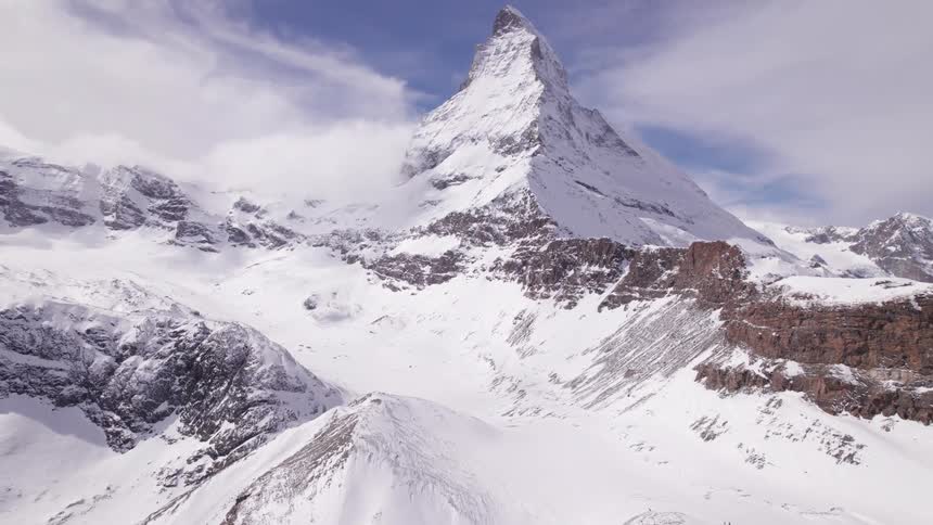 Aerial view of snowy mountains on a partly cloudy day