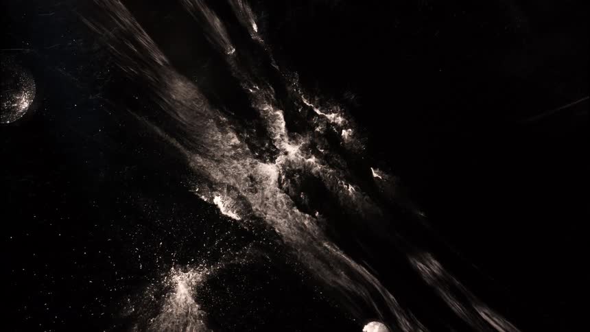 Wisps of light and dark particles swirl diagonally across a dark abstract background