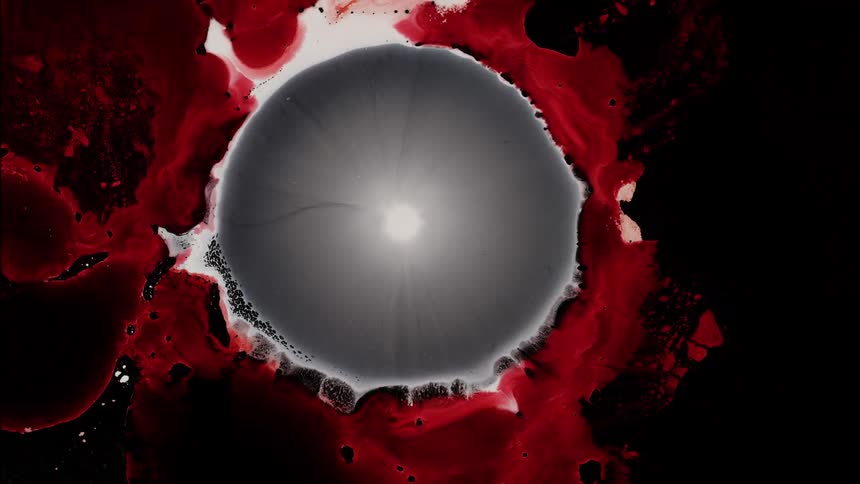 Liquid bubble of organic matter collapsing with a red liquid around it