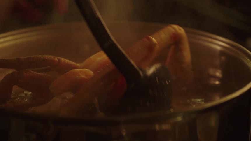 A woman is cooking seafood in a pot