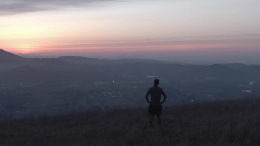 A man watches the sunrise on the mountain