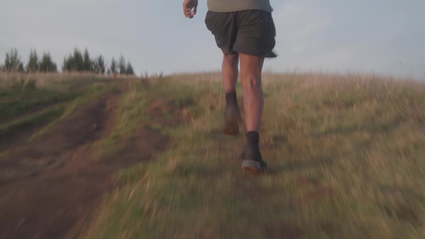 A man running across a grassland at midday